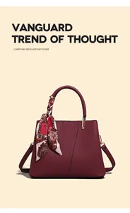 Close-up detail of the wine red handbag handle with elegant floral printed silk scarf decor.