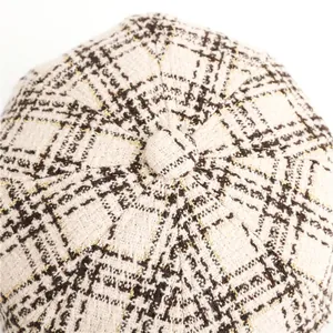 Close-up of plaid tweed newsboy hat with elegant gold metallic thread texture