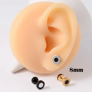 Detailopname van 8 mm roestvrijstalen oorknopjes met Grieks patroon op een oormodel