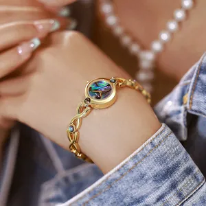 Reloj de mujer vintage en oro con esfera de concha de abulón natural puesto en la muñeca