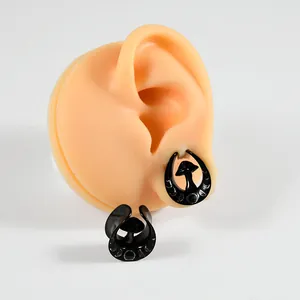 Macro detail of black U-shaped mushroom ear gauges on a professional silicone display model