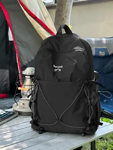 Sac à dos de camping noir durable avec logo Norvincy présenté dans un décor de camping naturel