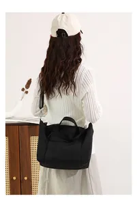Modello che indossa una borsa tote in nylon nero capiente per un look casual da ufficio