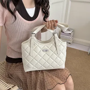 Elegante cremeweiße Stepptasche mit silbernen Beschlägen, präsentiert von einem Model