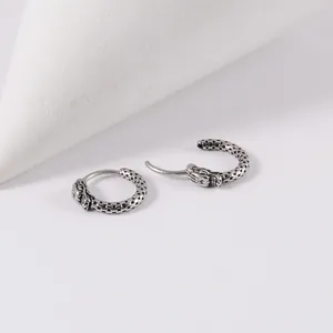 Vue détaillée de boucles d'oreilles dragon en acier inoxydable argenté antique texturé.