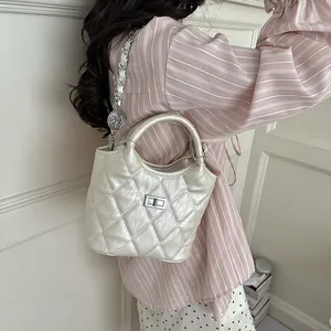 Detailed view of the silver quilted bucket bag with pearlized finish and metal lock