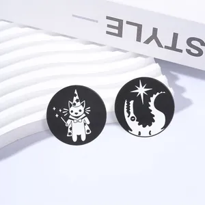 Close-up of circular black metal pins featuring a wizard cat and star crescent design.