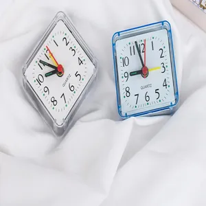 Detailed view of square analog student alarm clocks in blue and white colors on white fabric