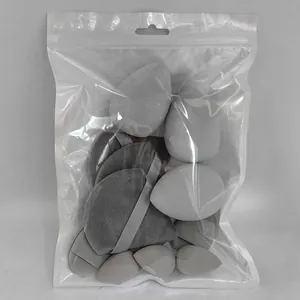 Detail view of grey makeup sponge and powder puff set in clear plastic packaging
