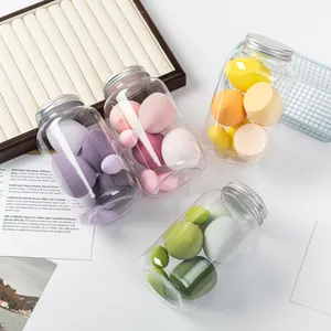 Detailed shot of colorful dual-use makeup sponges stored in clear jars on a desk