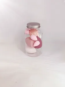 Detailed view of soft pink makeup sponges in a clear storage jar with silver lid