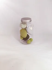 Detailed close-up of multi-colored makeup sponges inside a clear jar with a silver lid