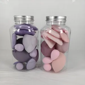 Detailed view of soft purple and pink makeup sponges and powder puffs in clear storage jars