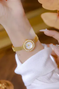 Detalle de primer plano de un elegante reloj dorado para mujer con bisel de girasol