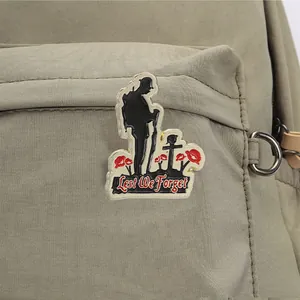 Detalle de un pin conmemorativo con silueta de soldado y amapolas rojas brillantes