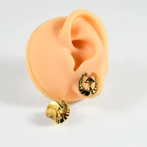 Detailed view of vintage gold mushroom and moon stainless steel U-shaped ear tunnel gauge