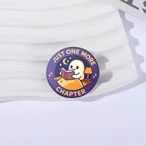 Gedetailleerde macro-opname van een schattige spookbadge met tekst Just One More Chapter