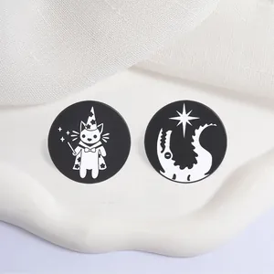 Macro view of black and white circular enamel pins featuring wizard cat and magic star designs.