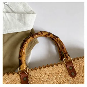 Detailaufnahme der retro strohgeflochtenen Handtasche mit Bambusgriff für den täglichen Gebrauch.
