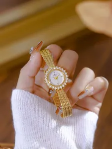 Primer plano de un reloj vintage dorado con forma de sol para mujer con diamantes