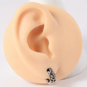 Manchette d'oreille en acier inoxydable avec dragon sculpté sur un modèle d'oreille réaliste