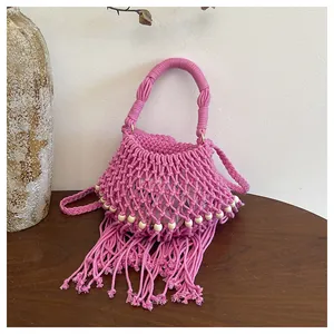 Handgemaakte roze macramé schoudertas met franje kwastjes en decoratieve houten kralen
