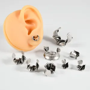 Ear cuff retrò color argento a forma di U avvolti da serpenti su un modello in silicone