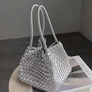Stylish silver metallic woven bucket bag featuring elegant braided top handles for women