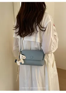 Borsa a tracolla azzurro polvere minimalista con ciondolo pony indossata da modella