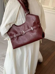Fashionable burgundy faux leather tote underarm bag with decorative buckle strap detail