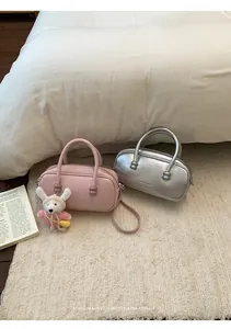 Detailed macro view of minimalist retro bowling bags in pink and metallic silver finishes