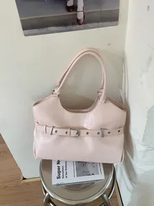 Stylish pink faux leather underarm tote bag displayed on a modern metallic stool
