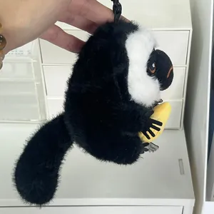 Adorable llavero de peluche de mono saki de cara blanca con un pequeño plátano amarillo