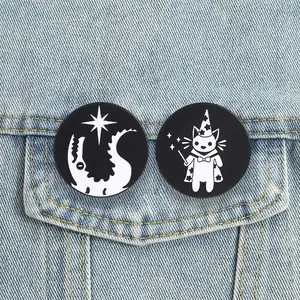 Detailed view of magic theme wizard cat and shadow creature metal enamel pins on denim