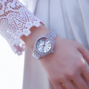 Elegante reloj plateado para mujer con incrustaciones de pedrería y manga de encaje.