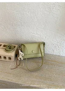 Elegante piccola borsa a tracolla verde chiaro minimalista con ciondolo in pelle a cavallo