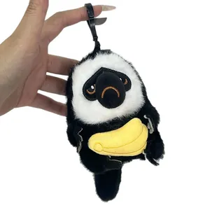 Lindo llavero de peluche de mono saki de cara blanca con un plátano para bolsos