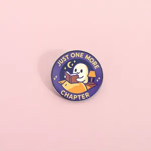 Emaille speldje met lezend spookje en tekst "Just one more chapter" voor lezers.
