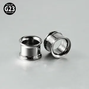 Detailed close-up of G23 solid titanium double flared ear tunnels with polished silver finish