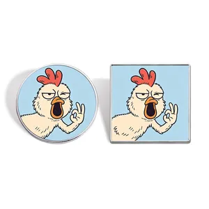 Set of circular and square metal enamel pins featuring a funny cartoon chicken making an OK sign.