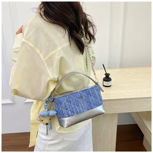 Borsa a tracolla in denim trapuntato blu con finiture argento e ciondolo a orsetto