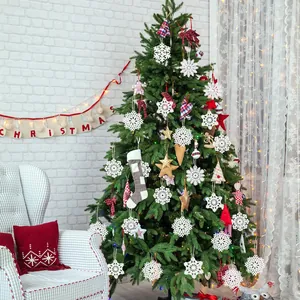 Witte PVC sneeuwvlok kerstornamenten hangend aan een prachtig versierde feestelijke boom