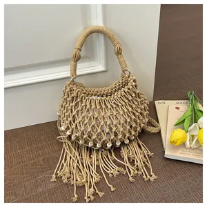 Detail van handgemaakte boho geweven tas met lange franjes en kralenaccenten