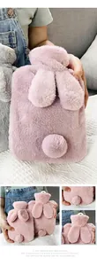 Close-up detail of a soft pink plush hot water bottle featuring cute bunny ears and a tail
