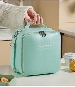 Dettaglio di una borsa termica portatile in PU verde menta con manico superiore e tracolla