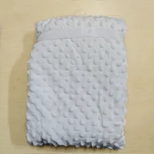 Détail d'une couverture en peluche minky à pois blancs doux avec motif de bulles texturé