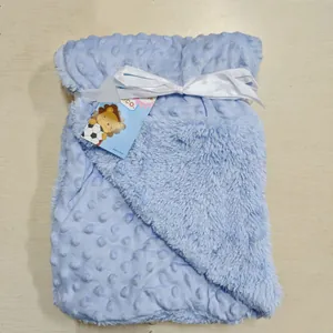 Vue détaillée d'une couverture pour bébé bleu clair à deux couches en polaire à bulles