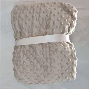 Gros plan d'une couverture en polaire à bulles douce avec motif à pois texturé