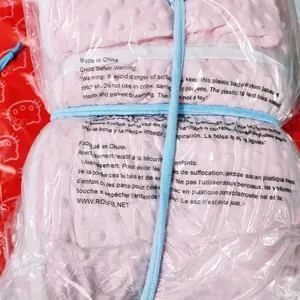 Couverture polaire rose à bulles sous emballage plastique avec avertissements de sécurité
