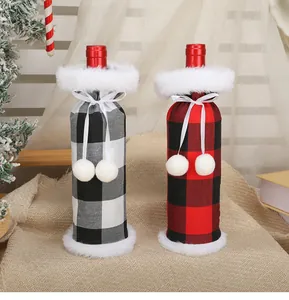 Pair of Christmas plaid wine bottle covers with white plush trim and pom-poms
